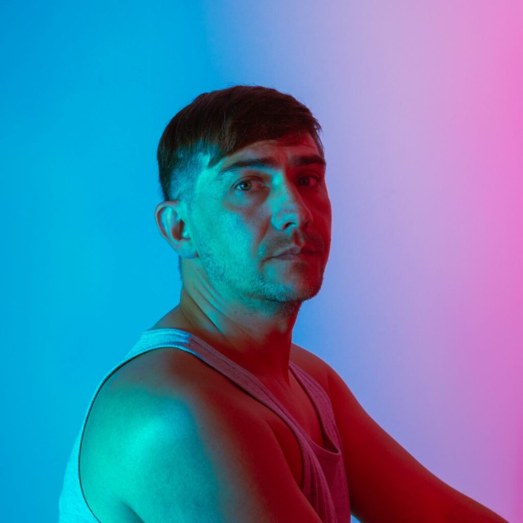 Portrait artistique d'un homme avec éclairage néon bleu et rose en studio