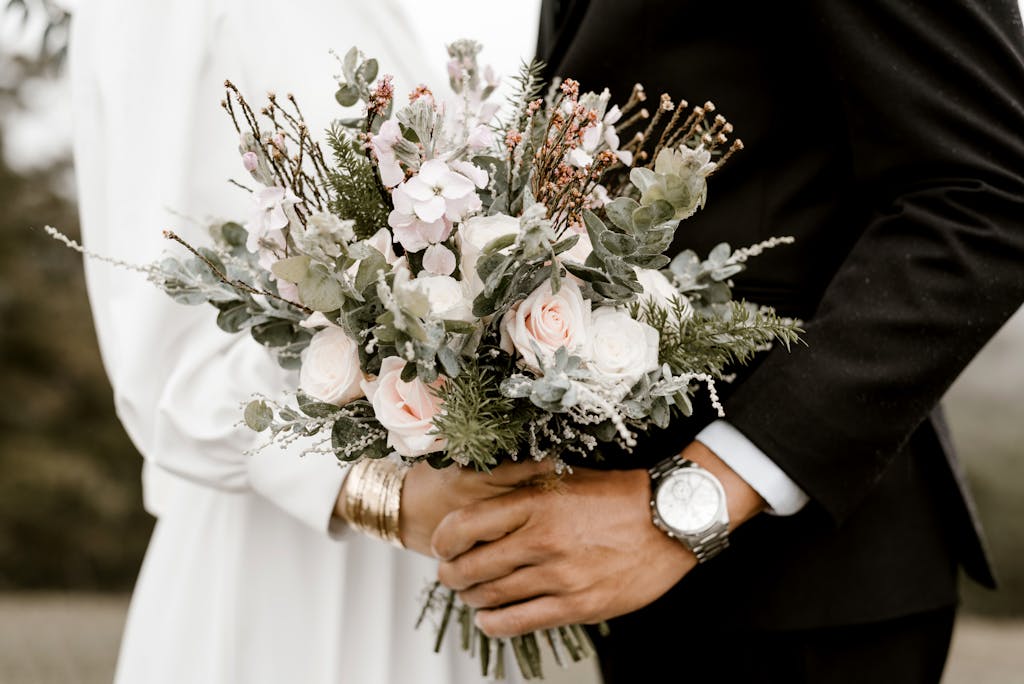 Bridge And Groom Standing While Holding Flower Bouquet