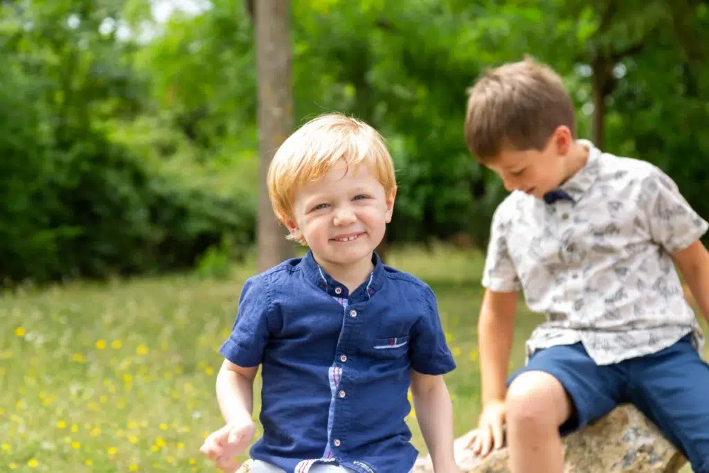 Deux jeunes garçons souriants photographiés en extérieur dans la nature